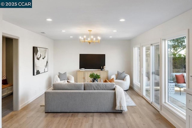 living room featuring an inviting chandelier and light hardwood / wood-style floors