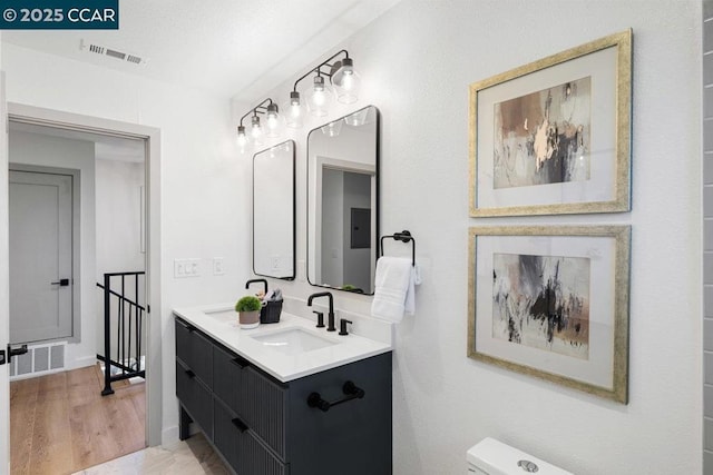 bathroom with wood-type flooring, vanity, and toilet