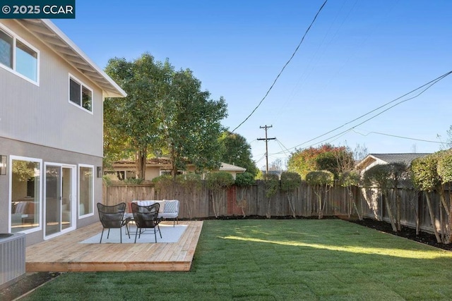 view of yard with a wooden deck and central air condition unit