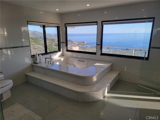 bathroom with toilet, a bath, and recessed lighting