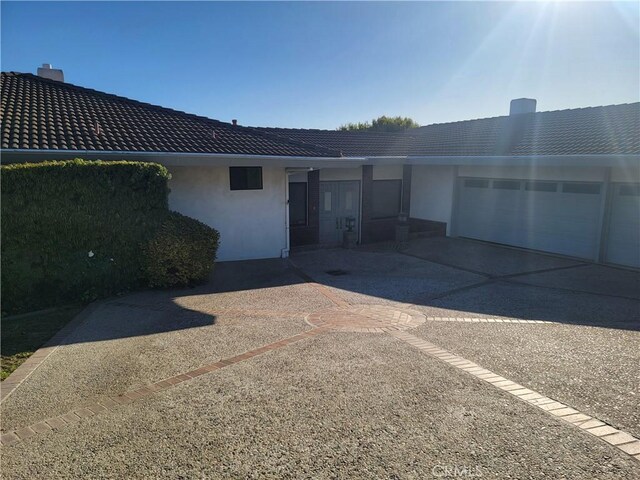 exterior space with an attached garage, driveway, and stucco siding