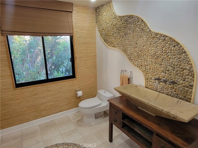 bathroom featuring toilet, baseboards, and tile patterned floors