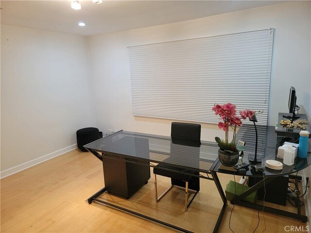 office area with baseboards and light wood finished floors