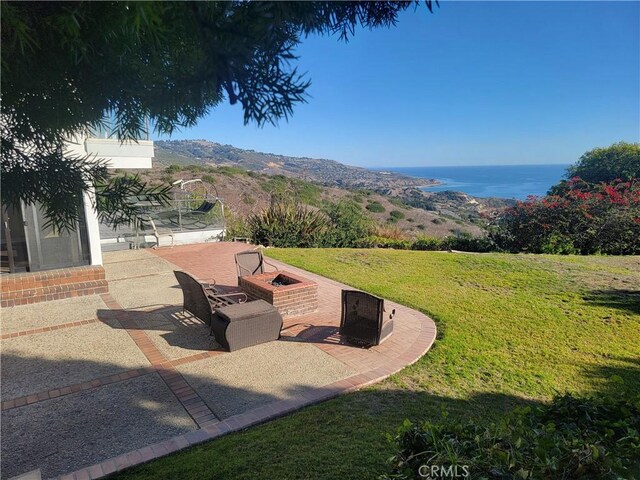 view of yard with a patio, an outdoor fire pit, and a mountain view