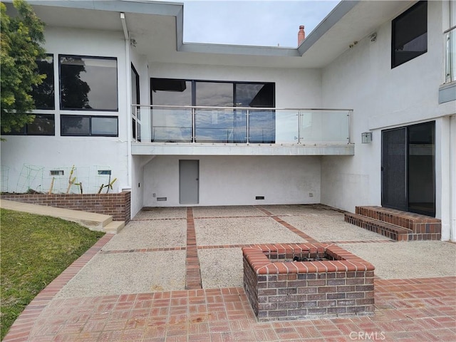 back of property featuring a patio area, a balcony, and stucco siding