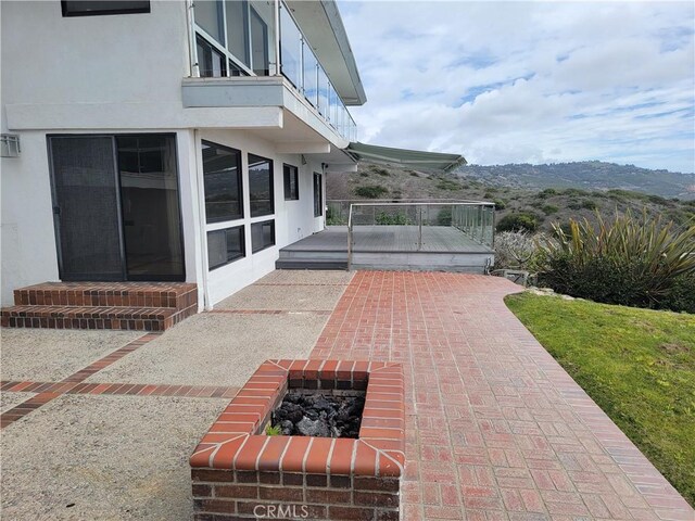 view of patio featuring a mountain view and a balcony