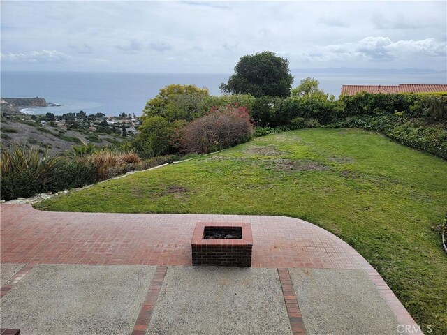 view of yard with a water view, an outdoor fire pit, and a patio