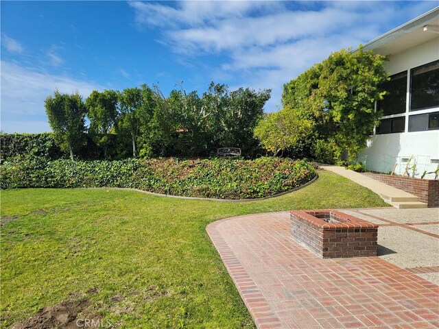 view of yard featuring an outdoor fire pit and a patio area