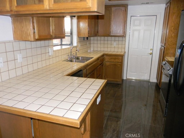 kitchen featuring sink, tile countertops, dark tile patterned flooring, and decorative backsplash