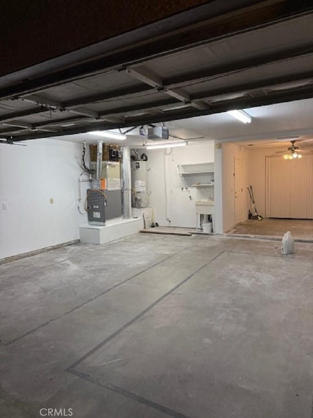 garage with water heater, ceiling fan, and heating unit