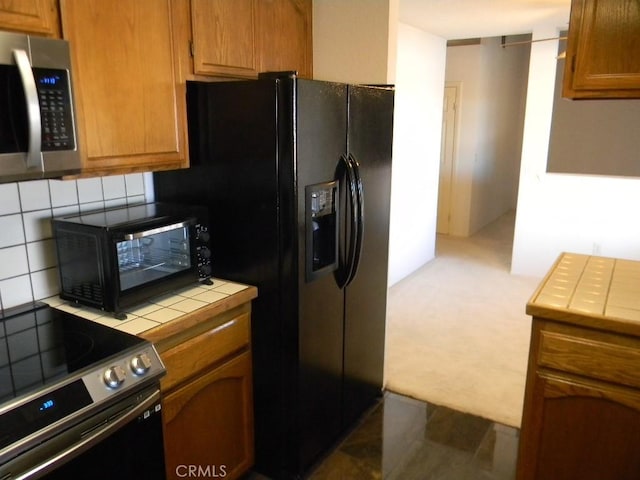 kitchen with tile counters, tasteful backsplash, and appliances with stainless steel finishes