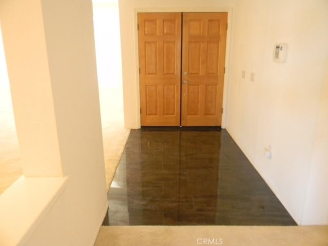 hallway with dark tile patterned flooring