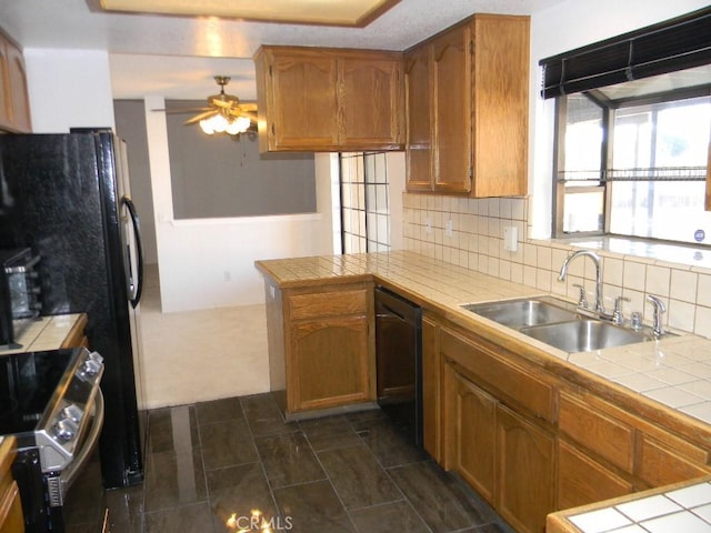 kitchen featuring sink, dishwasher, stainless steel electric range, and tile countertops