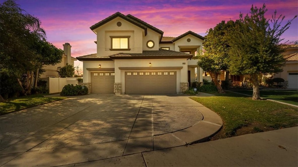 mediterranean / spanish house featuring a lawn and a garage