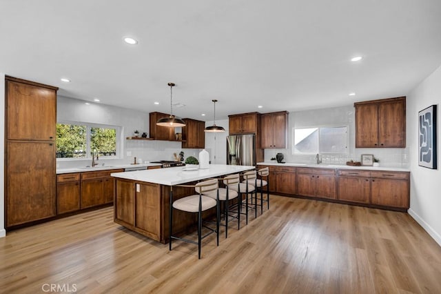 kitchen with sink, a center island, decorative light fixtures, and tasteful backsplash