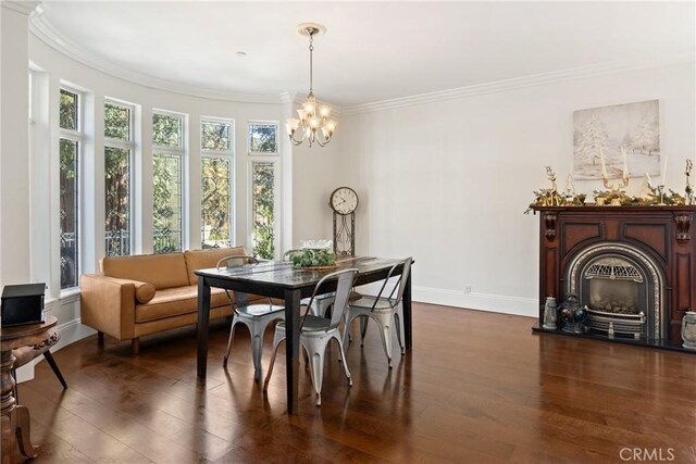 dining room featuring dark hardwood / wood-style flooring, ornamental molding, and an inviting chandelier