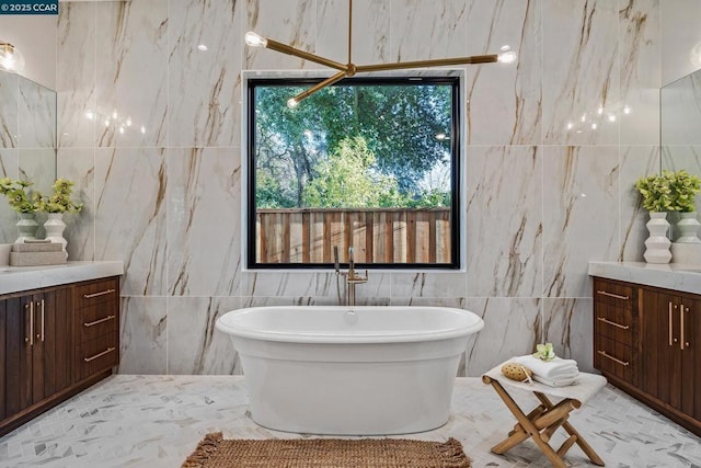 bathroom with tile walls, a bathing tub, and vanity