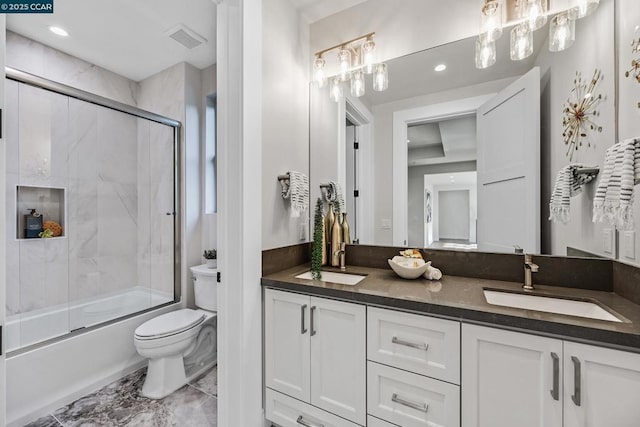 full bathroom featuring bath / shower combo with glass door, vanity, and toilet