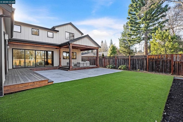 back of house with a lawn, a deck, and a patio