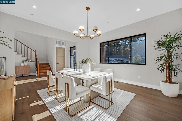 dining space with dark hardwood / wood-style flooring and a chandelier