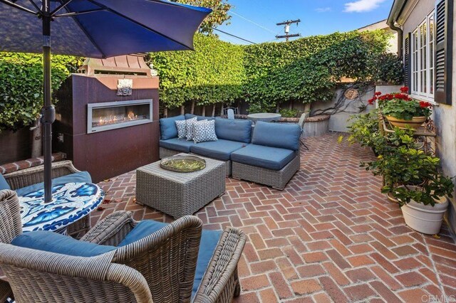 view of patio / terrace with an outdoor living space with a fireplace