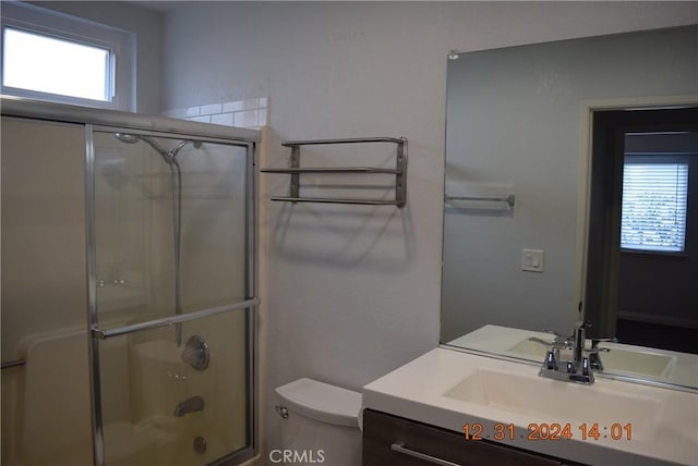 full bathroom featuring toilet, vanity, and bath / shower combo with glass door