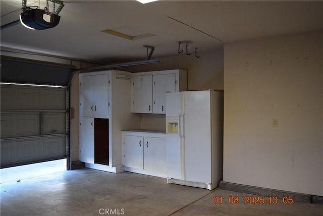 garage featuring white refrigerator with ice dispenser and a garage door opener