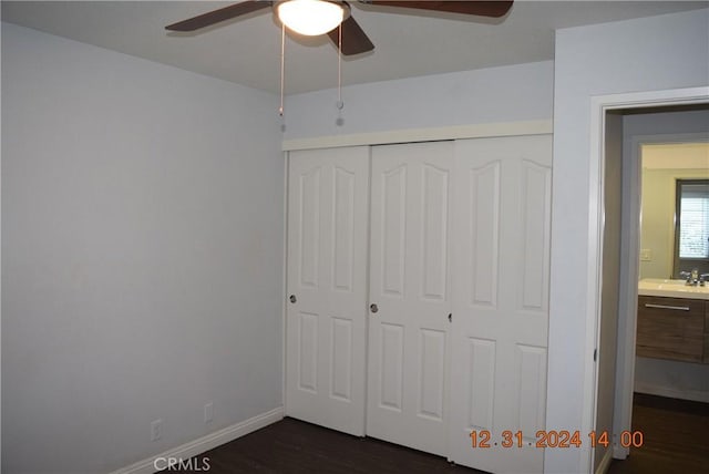 unfurnished bedroom with ceiling fan, dark hardwood / wood-style floors, a closet, and sink