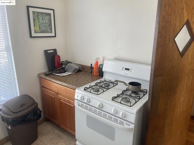 kitchen with white range with gas cooktop and light tile patterned floors