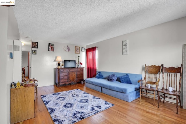 living room with a textured ceiling and hardwood / wood-style floors