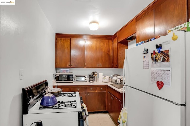 kitchen with white appliances and light tile patterned floors