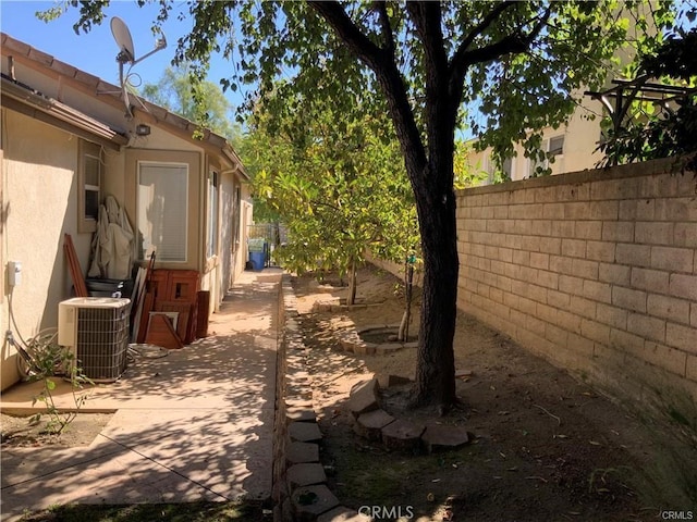 view of yard with central AC and a patio