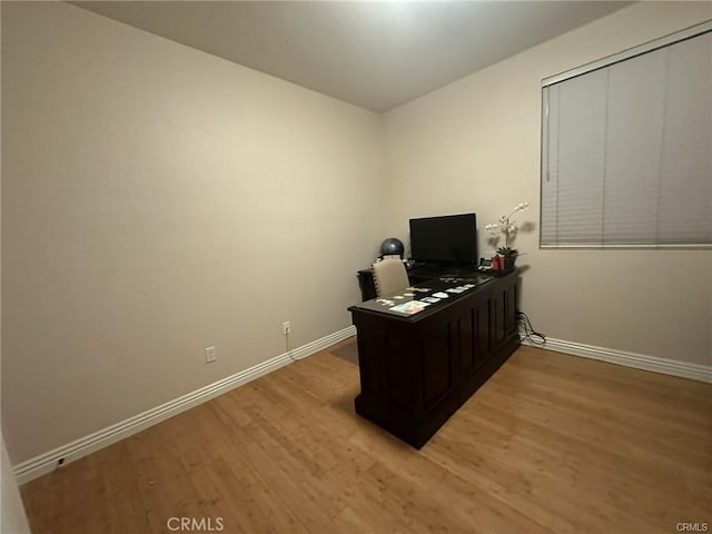 home office with light hardwood / wood-style flooring