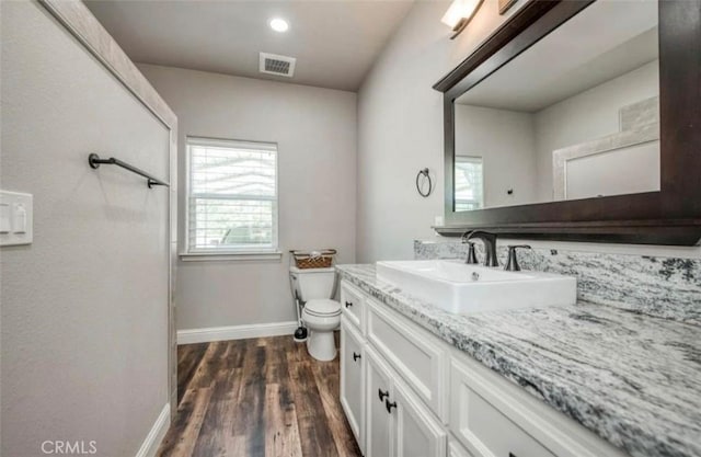 bathroom with hardwood / wood-style floors, vanity, and toilet