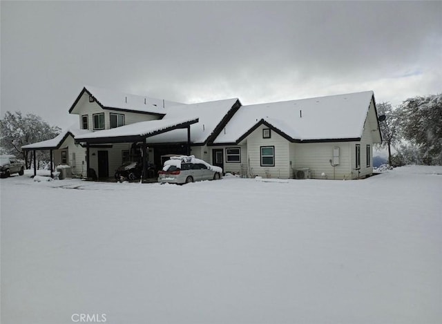 view of snow covered back of property