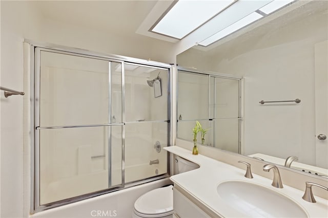 full bathroom featuring combined bath / shower with glass door, vanity, and toilet