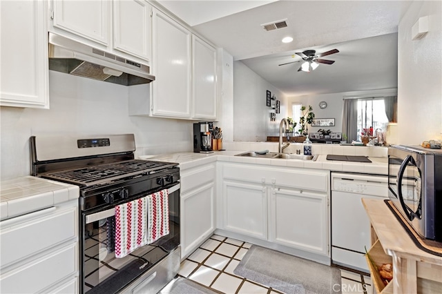 kitchen with sink, white cabinets, dishwasher, tile countertops, and stainless steel gas range oven