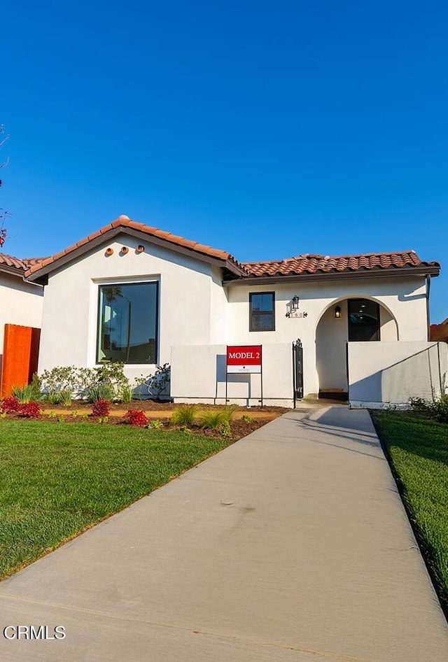 mediterranean / spanish-style house with a front yard