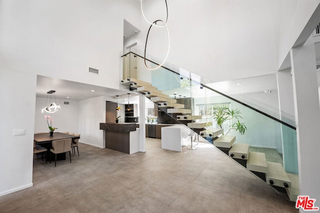 stairs featuring a towering ceiling and concrete flooring