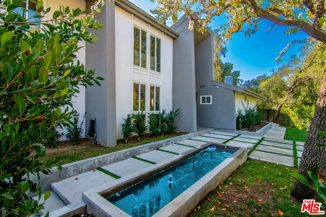 back of property featuring a swimming pool