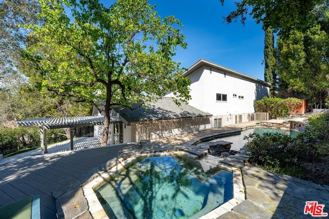 view of pool featuring a wooden deck and a pergola