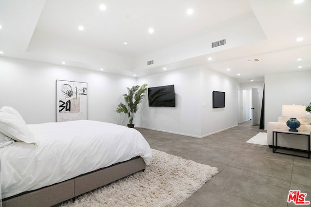 bedroom featuring concrete flooring and a tray ceiling