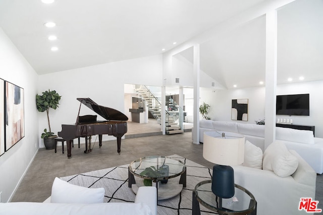 living room featuring concrete floors and high vaulted ceiling