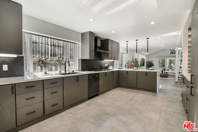 kitchen with sink, gray cabinetry, decorative light fixtures, kitchen peninsula, and wall chimney range hood