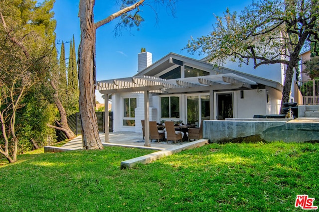 rear view of house featuring a yard, a pergola, and a patio