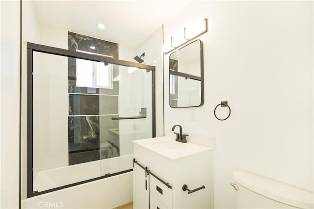 full bathroom featuring toilet, enclosed tub / shower combo, and vanity