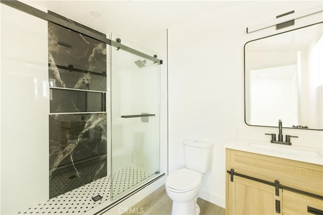 bathroom featuring toilet, a shower with door, wood-type flooring, and vanity