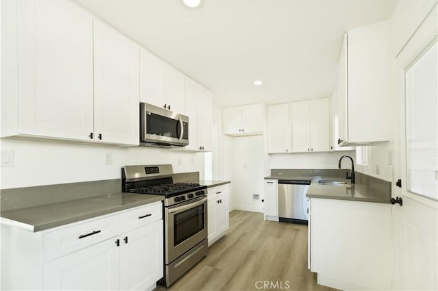 kitchen featuring sink, appliances with stainless steel finishes, and white cabinetry