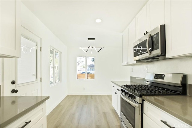 kitchen with white cabinets, a chandelier, and appliances with stainless steel finishes