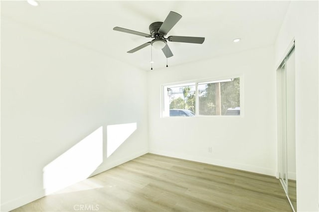 empty room with ceiling fan and light hardwood / wood-style floors